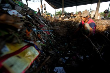 BALI, INDONESIA  APRIL 11: Poor from Java island working in a scavenging at the dump on April 11, 2012 on Bali, Indonesia. Bali daily produced 10,000 cubic meters of waste.
